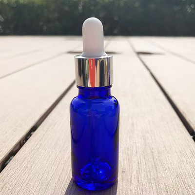 Bottle de verre vide d' huile essentielle bleue matte réutilisable et recyclable
