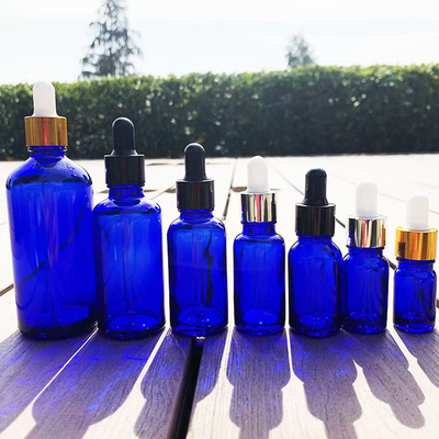 Bottle de verre vide d' huile essentielle bleue matte réutilisable et recyclable